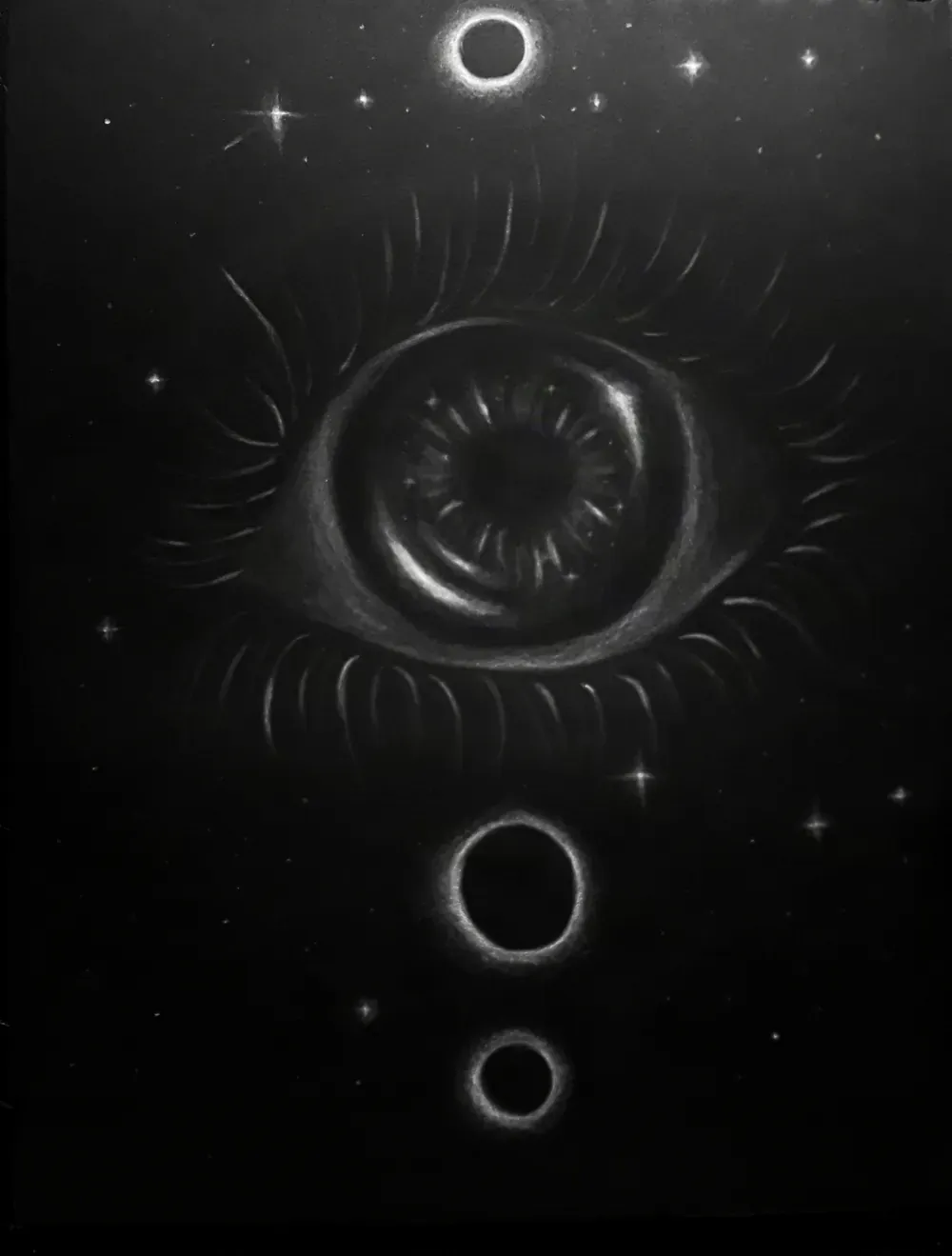 White charcoal drawing on black paper of a large eye surrounded by lashes, with eclipsing rings above and below it in a starfield