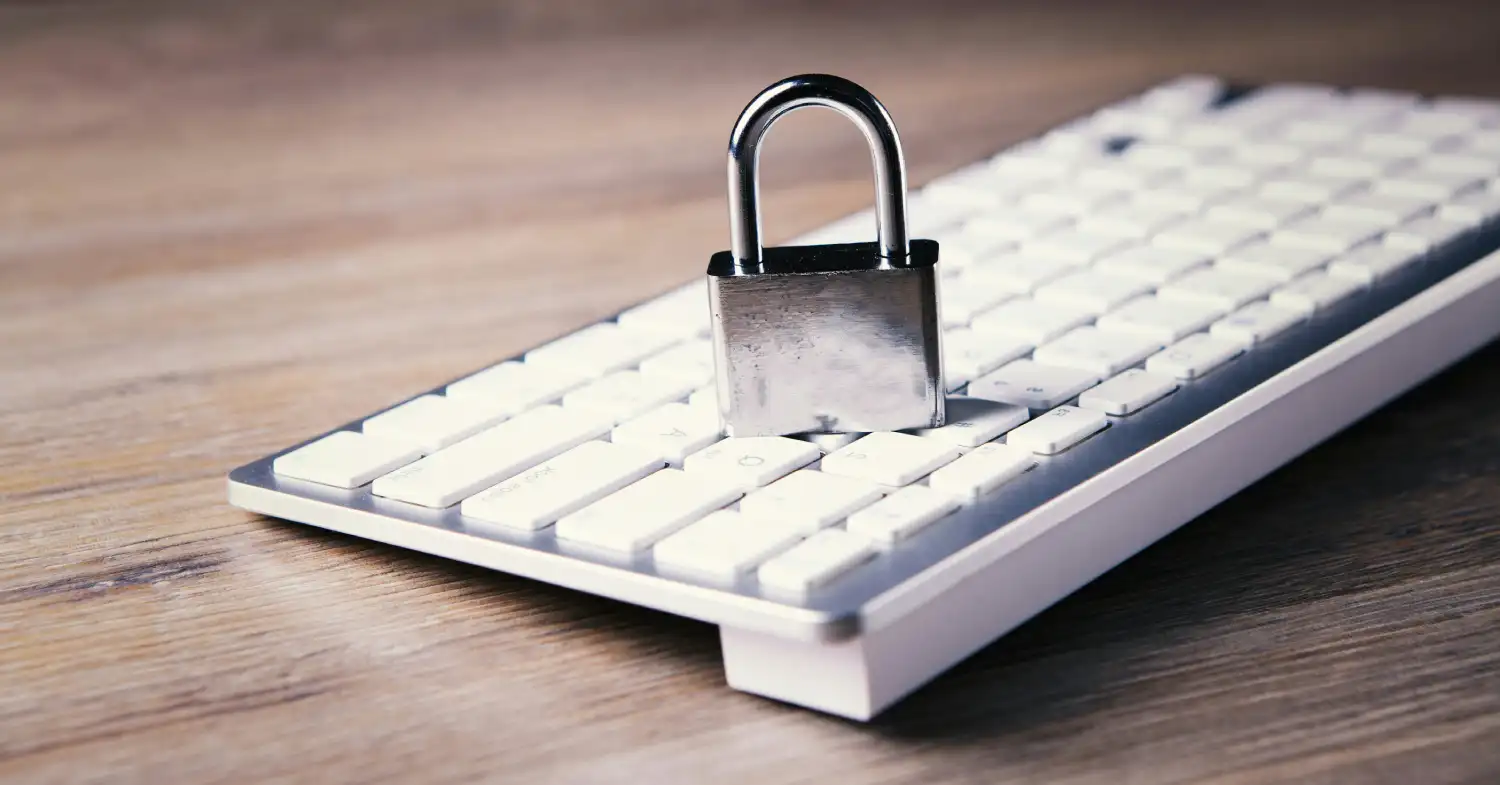 A metallic padlock resting on a computer keyboard, representing data privacy and secure file access management for AI coding tools.