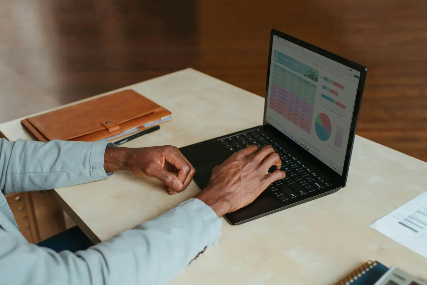 Close-up of a front-end developer's hands typing on a laptop keyboard, reviewing data charts and user experience analytics to optimize website conversion rates.